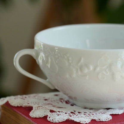 Tasse "Gisèle" à deux hanses en porcelaine de Limoges aux reliefs végétaux et fruités