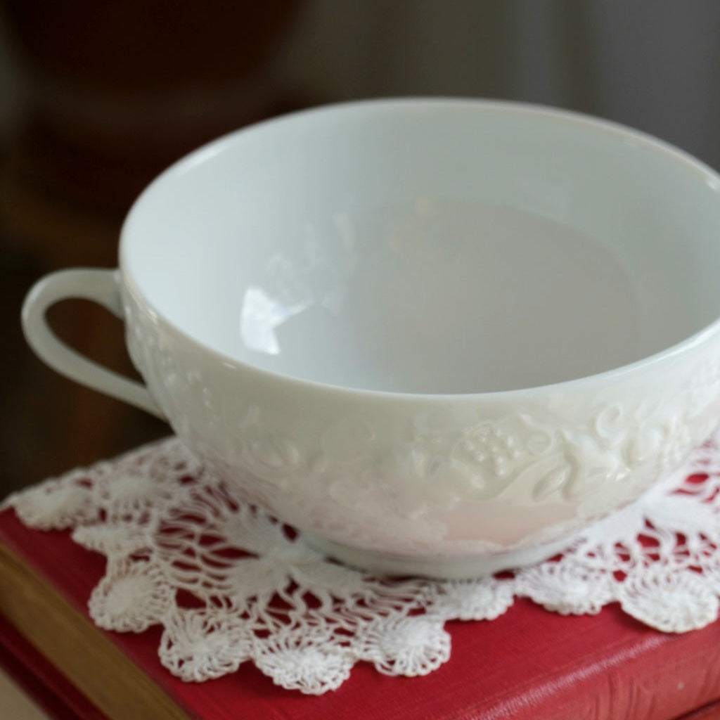Tasse "Gisèle" à deux hanses en porcelaine de Limoges aux reliefs végétaux et fruités