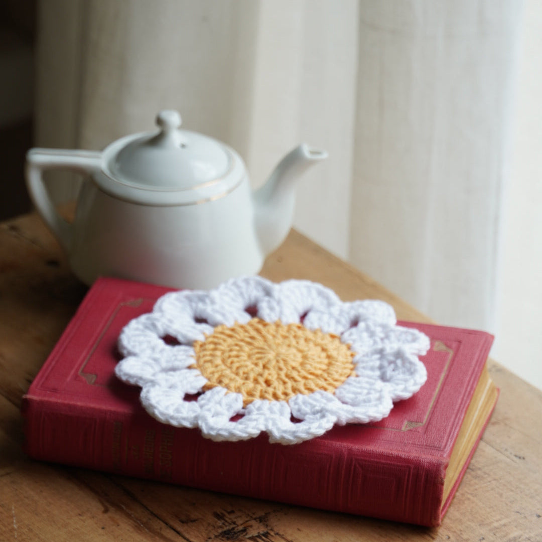 Sous-tasse "Marguerite" en crochet en forme de fleur au coeur jaune et pétales blanches
