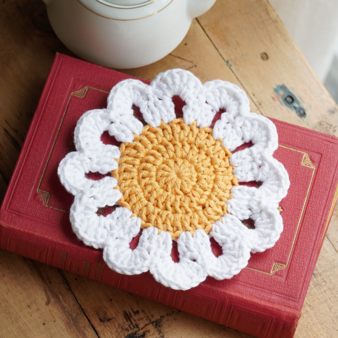 Sous-tasse "Marguerite" en crochet en forme de fleur au coeur jaune et pétales blanches
