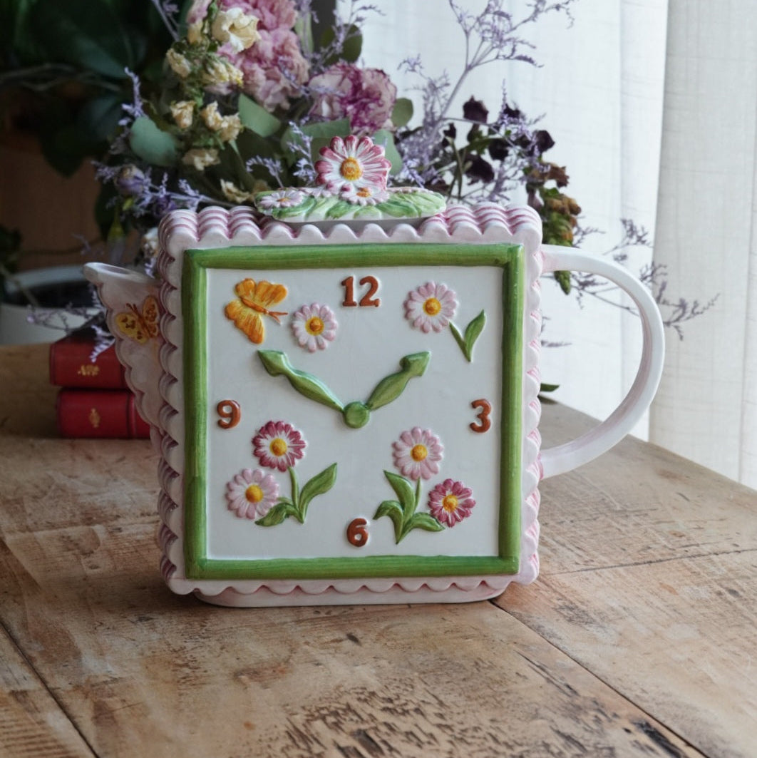 Théière "Lanette" en barbotine fleurie rectangulaire avec motifs d'horloge et d'un visage