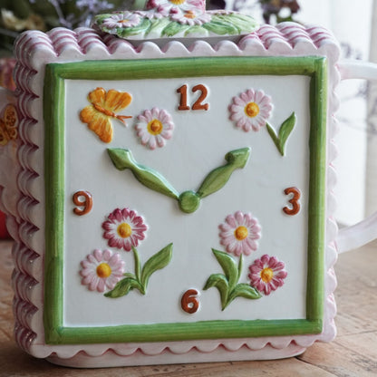 Théière "Lanette" en barbotine fleurie rectangulaire avec motifs d'horloge et d'un visage