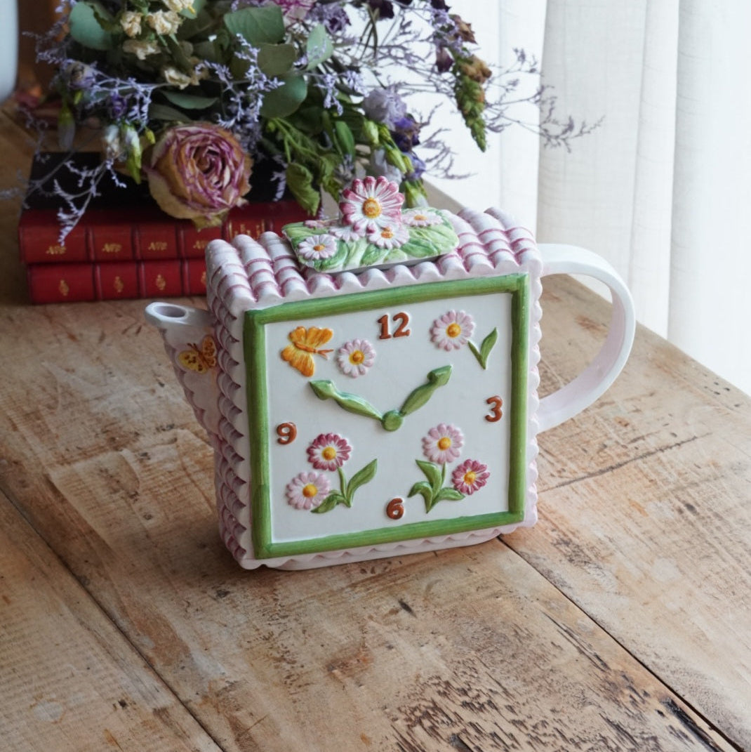 Théière "Lanette" en barbotine fleurie rectangulaire avec motifs d'horloge et d'un visage