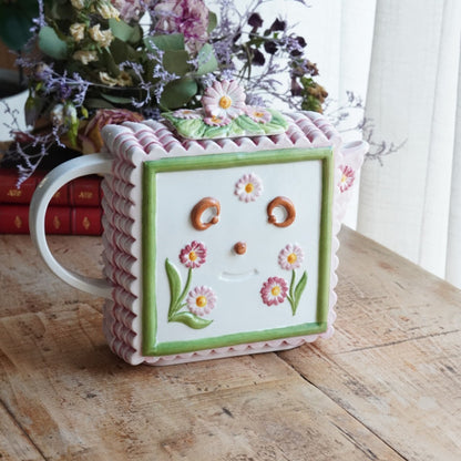 Théière "Lanette" en barbotine fleurie rectangulaire avec motifs d'horloge et d'un visage