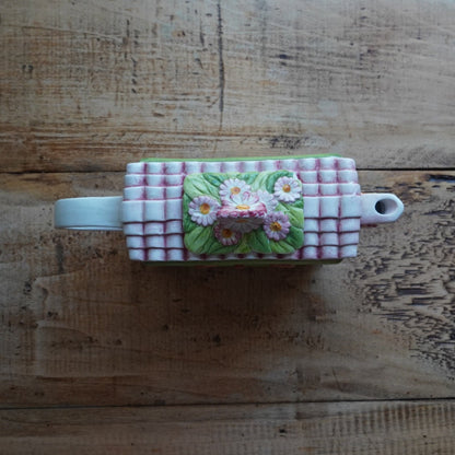 Théière "Lanette" en barbotine fleurie rectangulaire avec motifs d'horloge et d'un visage