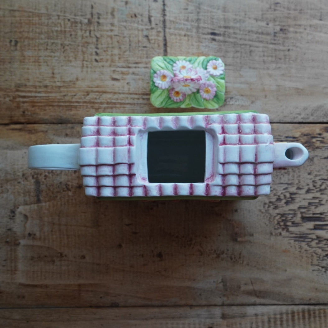 Théière "Lanette" en barbotine fleurie rectangulaire avec motifs d'horloge et d'un visage