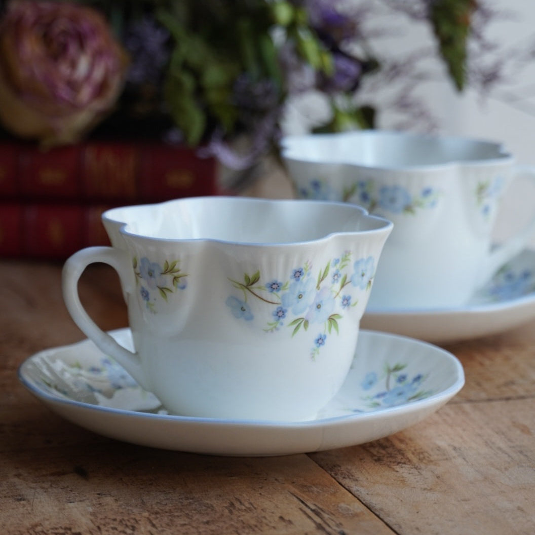 Tête-à-tête de tasses "Harmony" en porcelaine anglaise fleurie bleutée aux bordures festonnées Crown Staffordshire modèle Roch Garden