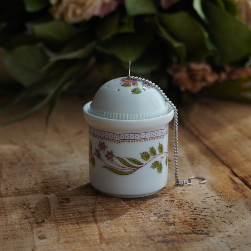 Boule à thé "Mancielle" en porcelaine fleurie et son support en porcelaine de Paris