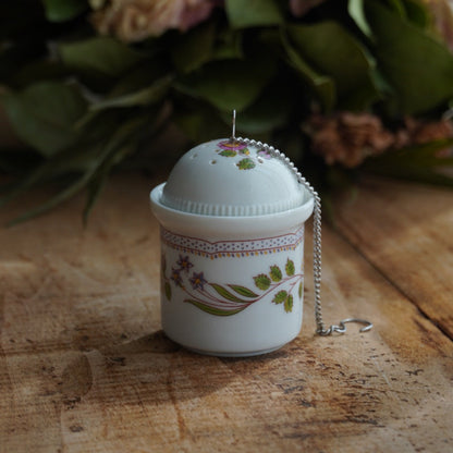 Boule à thé "Mancielle" en porcelaine fleurie et son support en porcelaine de Paris