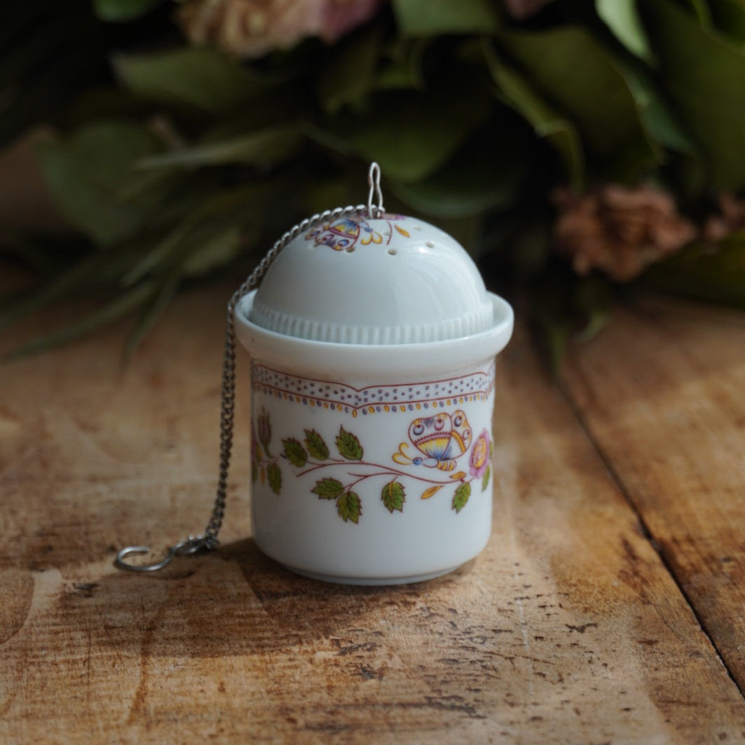 Boule à thé "Mancielle" en porcelaine fleurie et son support en porcelaine de Paris