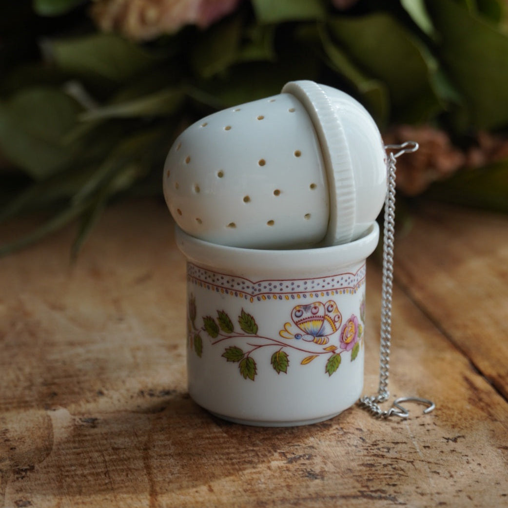 Boule à thé "Mancielle" en porcelaine fleurie et son support en porcelaine de Paris
