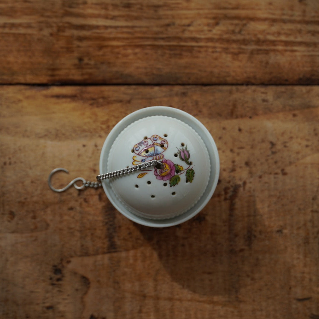 Boule à thé "Mancielle" en porcelaine fleurie et son support en porcelaine de Paris