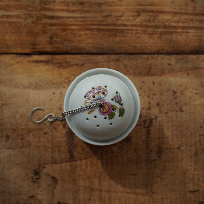 Boule à thé "Mancielle" en porcelaine fleurie et son support en porcelaine de Paris