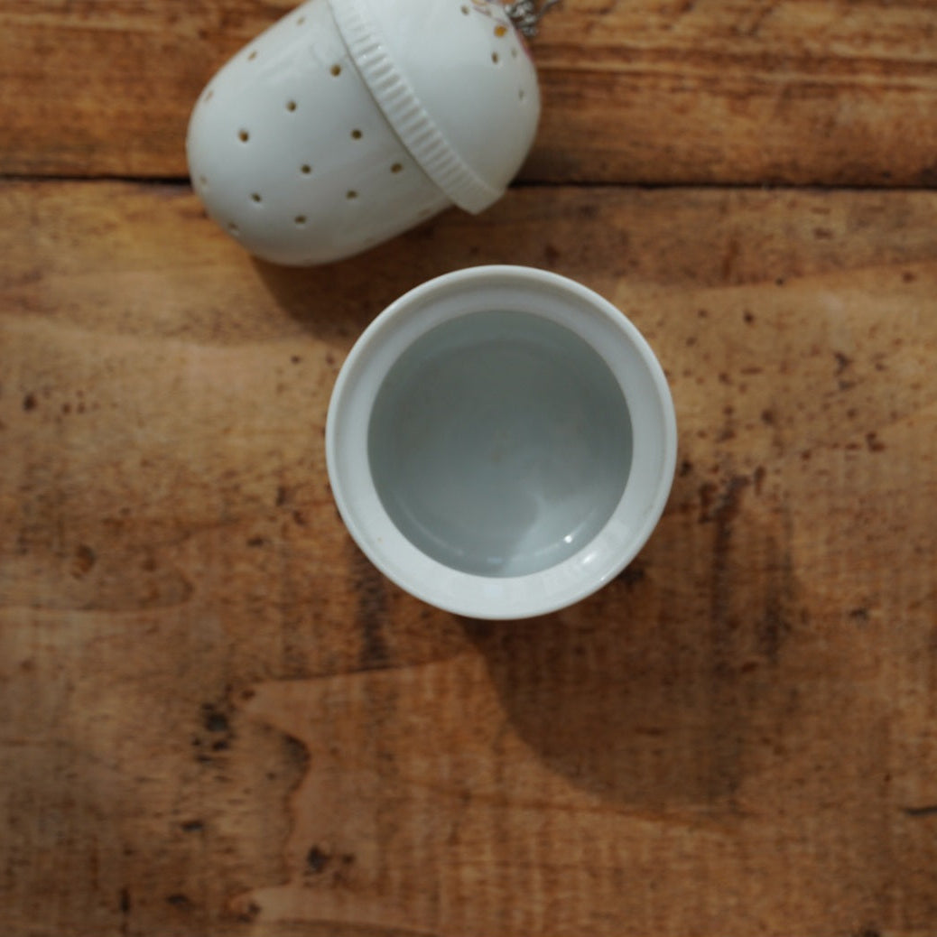 Boule à thé "Mancielle" en porcelaine fleurie et son support en porcelaine de Paris