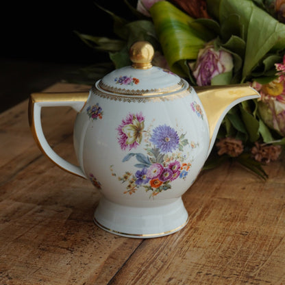 Théière "Laudore" en porcelaine de Limoges fleurie et dorée T.L.B