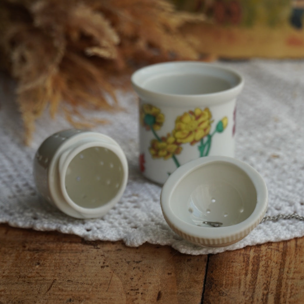 Boule à thé "Nalidée" en porcelaine fleurie et son support en porcelaine de Paris décor Herbier
