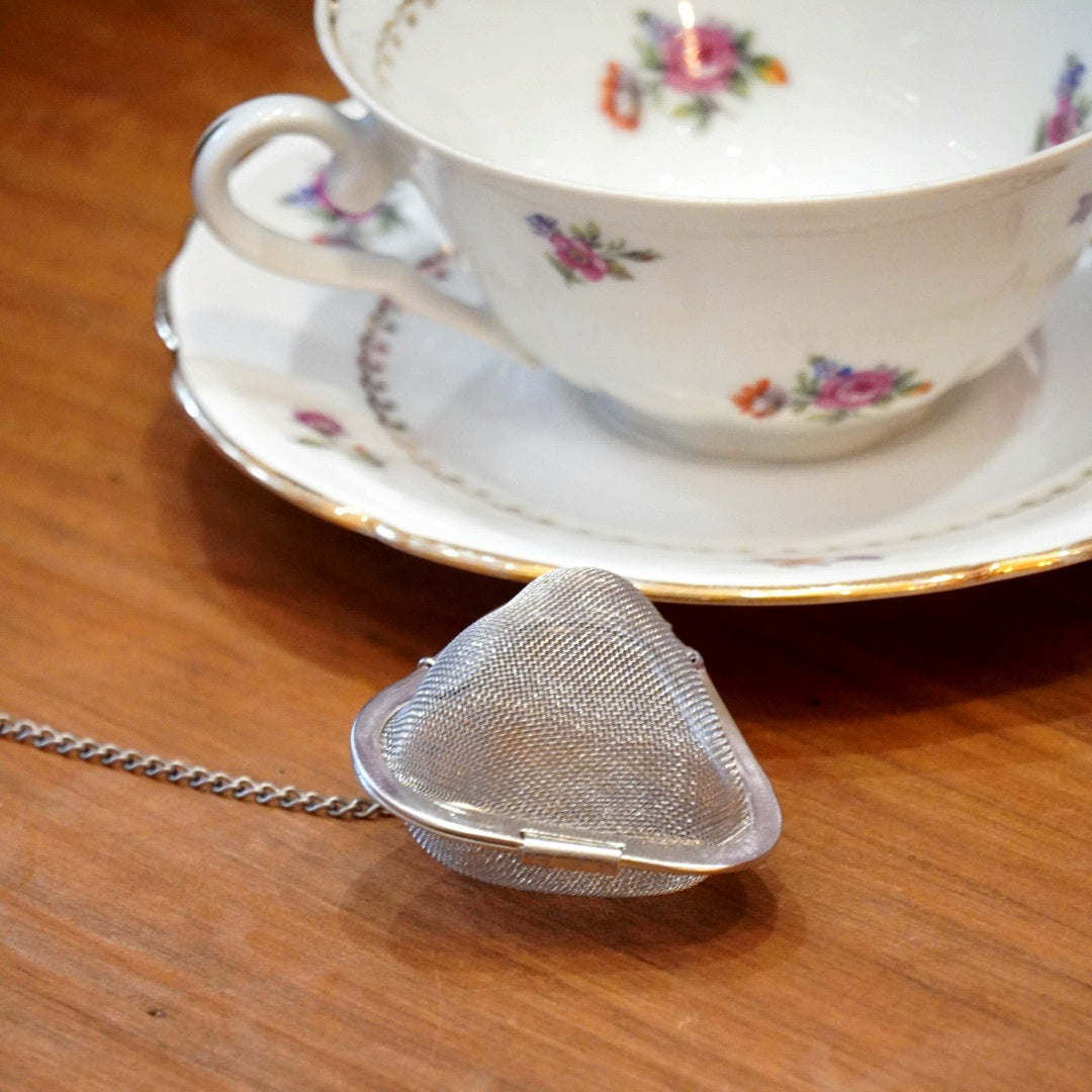 Case n°20 | Tasse en porcelaine fleurie et dorée de Limoges & boule à infuser le thé en forme de cœur