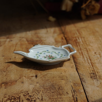 Repose-sachet "Hélion" en porcelaine de Limoges fleurie et dorée en forme de théière Raynaud