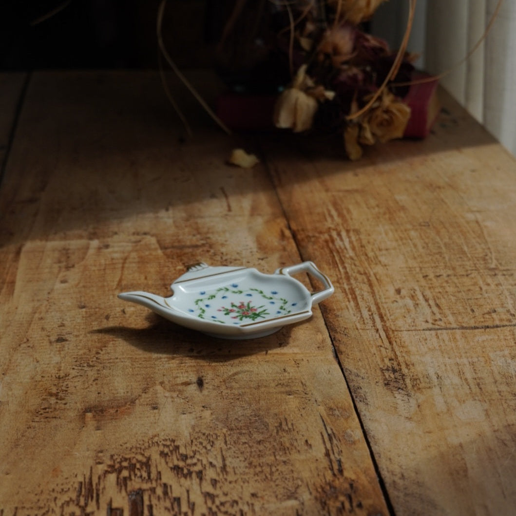 Repose-sachet "Hélion" en porcelaine de Limoges fleurie et dorée en forme de théière Raynaud