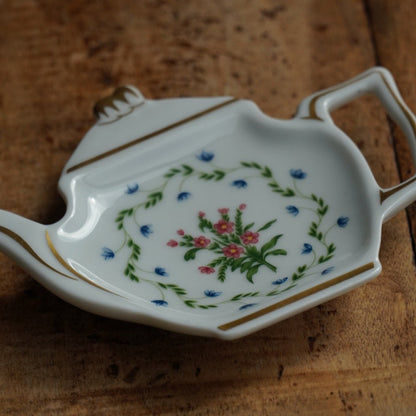 Repose-sachet "Hélion" en porcelaine de Limoges fleurie et dorée en forme de théière Raynaud